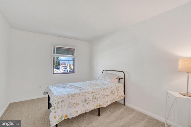 bedroom with baseboards and carpet