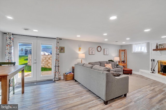 living area with french doors, recessed lighting, light wood-style flooring, and baseboards
