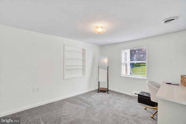 carpeted office space featuring a textured ceiling, built in features, baseboards, a baseboard heating unit, and visible vents