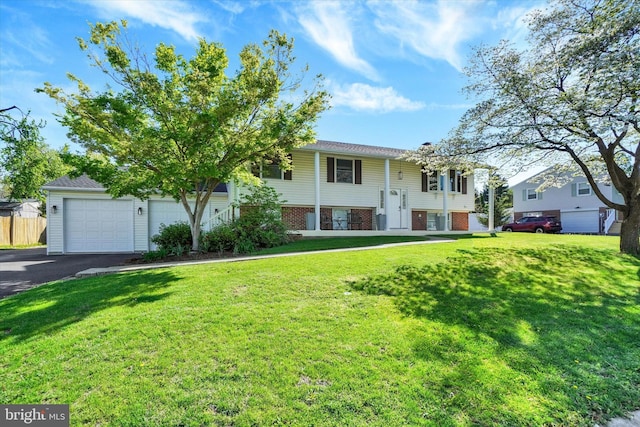 raised ranch with fence, driveway, and a front yard