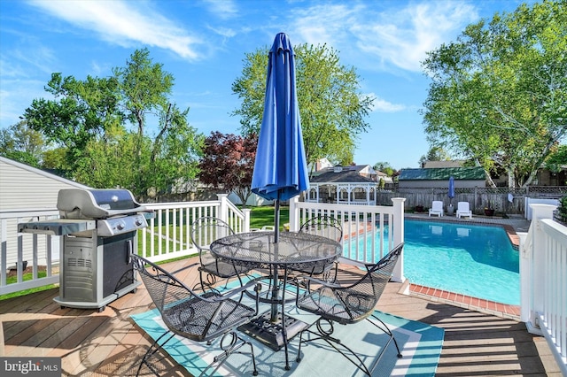 view of swimming pool with a fenced backyard, outdoor dining space, area for grilling, and a deck