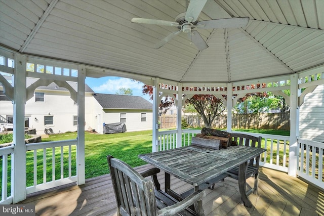 deck featuring a yard, ceiling fan, outdoor dining area, and a gazebo