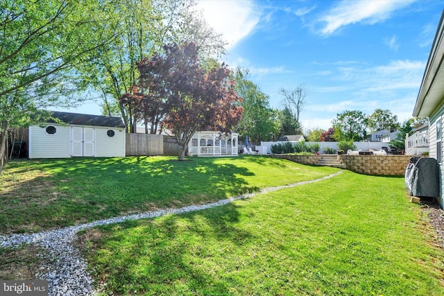 view of yard with a fenced backyard, an outdoor structure, and a shed