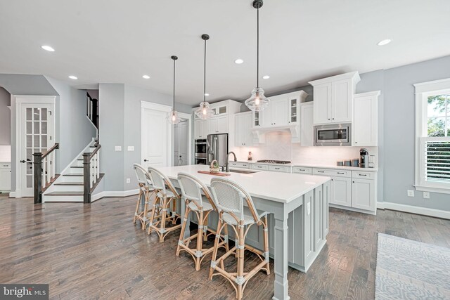 41972 Paddock Gate Pl, Ashburn, VA 20148 - kitchen featuring baseboards, a kitchen island with sink, recessed lighting, dark wood-type flooring, and light countertops