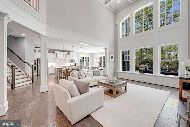 41972 Paddock Gate Pl, Ashburn, VA 20148 - living area featuring a towering ceiling, ornate columns, wood-type flooring, plenty of natural light, and recessed lighting