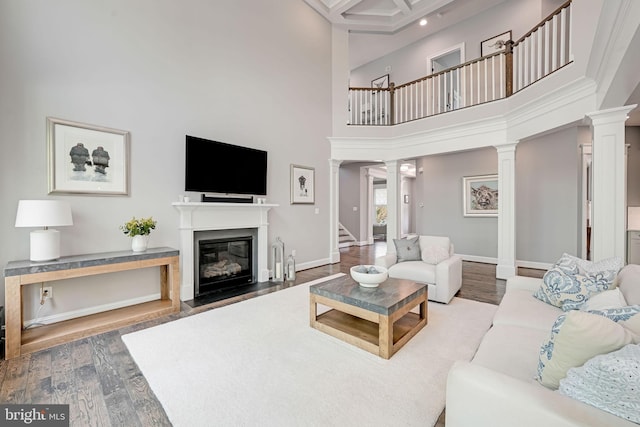 41972 Paddock Gate Pl, Ashburn, VA 20148 - living room with ornate columns, wood finished floors, a fireplace with flush hearth, stairs, and a high ceiling