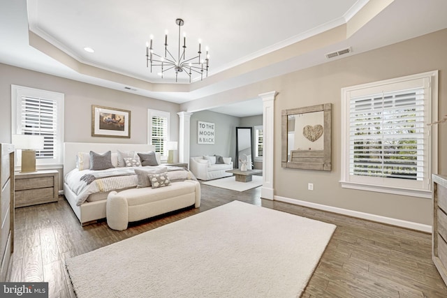 41972 Paddock Gate Pl, Ashburn, VA 20148 - bedroom featuring ornate columns, a tray ceiling, crown molding, wood finished floors, and a chandelier