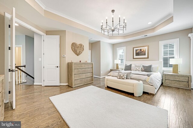 41972 Paddock Gate Pl, Ashburn, VA 20148 - bedroom featuring a raised ceiling, ornamental molding, wood finished floors, a chandelier, and baseboards