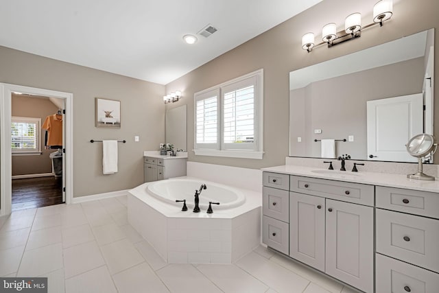 41972 Paddock Gate Pl, Ashburn, VA 20148 - full bath with a garden tub, tile patterned floors, baseboards, and two vanities