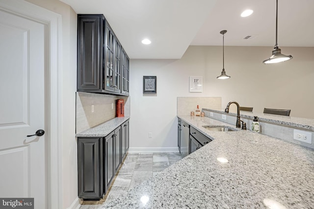 41972 Paddock Gate Pl, Ashburn, VA 20148 - kitchen featuring a sink, baseboards, light stone counters, and decorative backsplash