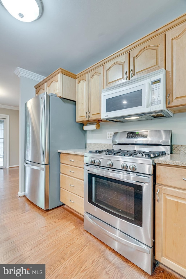 kitchen with light brown cabinets, light countertops, stainless steel appliances, light wood-type flooring, and ornamental molding