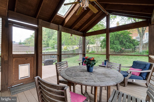 sunroom featuring a ceiling fan, outdoor dining area, and a skylight