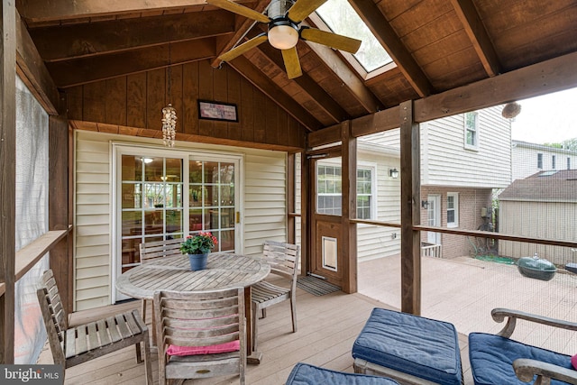 sunroom / solarium with outdoor dining area, ceiling fan, a skylight, and beam ceiling