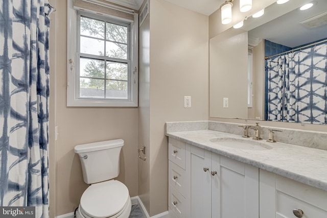 bathroom with vanity, baseboards, toilet, and visible vents