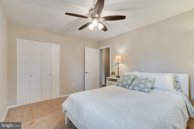 carpeted bedroom featuring a closet, a ceiling fan, and baseboards