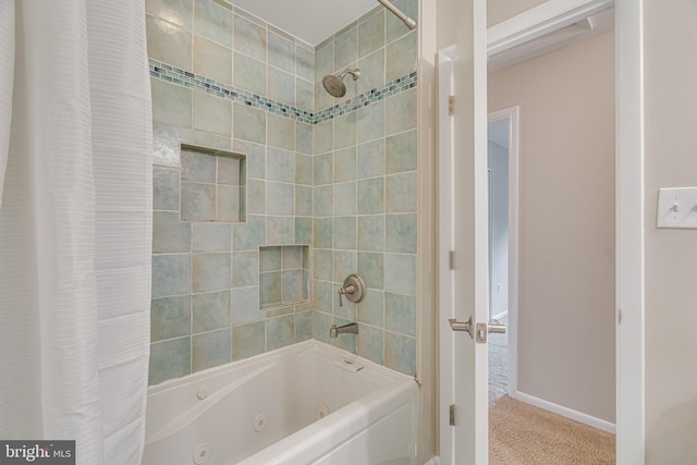 full bath with baseboards and a combined bath / shower with jetted tub