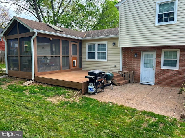 back of property with brick siding, a wooden deck, a sunroom, a patio area, and a yard
