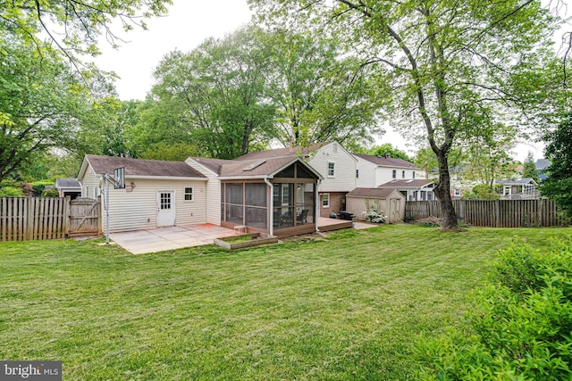 rear view of property with an outdoor structure, a sunroom, a shed, a fenced backyard, and a patio