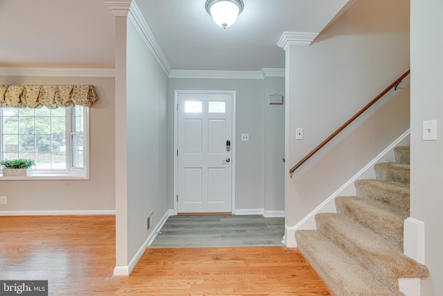 entryway with crown molding, stairs, baseboards, wood finished floors, and visible vents