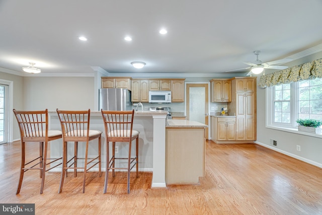 kitchen featuring freestanding refrigerator, crown molding, plenty of natural light, and white microwave