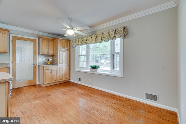kitchen with visible vents, light countertops, baseboards, and ornamental molding