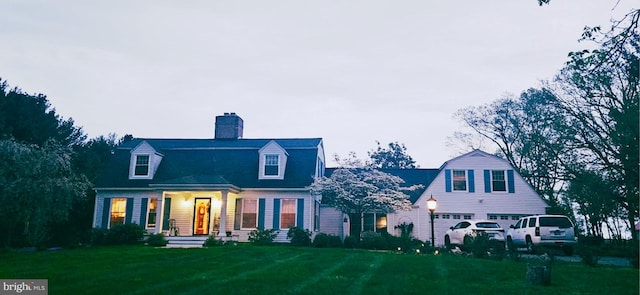 colonial inspired home featuring a garage, a front lawn, and a chimney