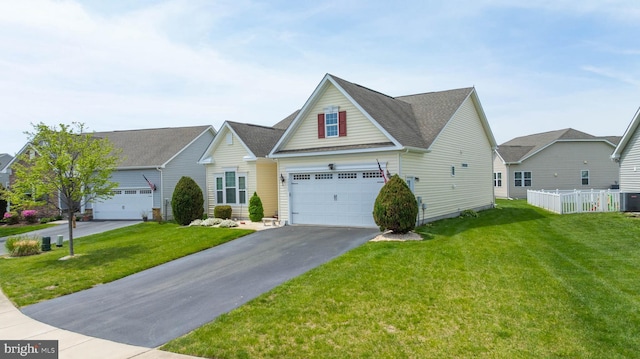 traditional-style house featuring a front lawn, central AC unit, a shingled roof, and aphalt driveway