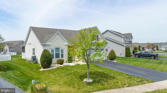 view of front facade with a front lawn, cooling unit, and a residential view