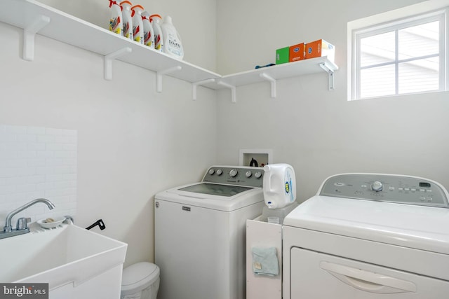 washroom featuring washer and dryer, a sink, and laundry area