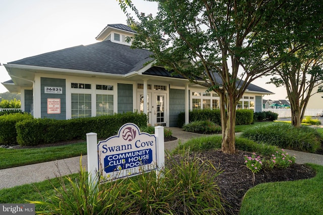 exterior space featuring a shingled roof and french doors