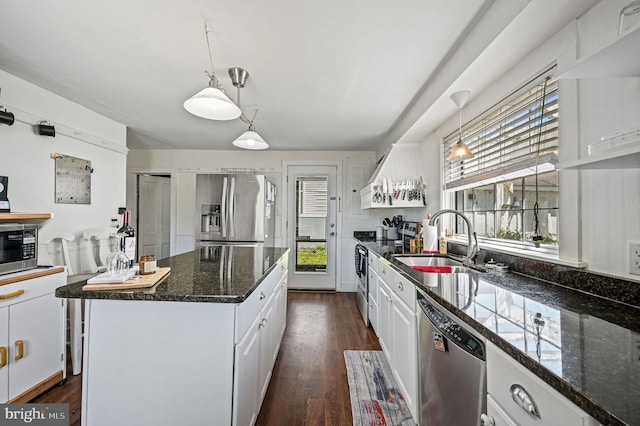 kitchen featuring a sink, a kitchen island, white cabinets, and stainless steel appliances