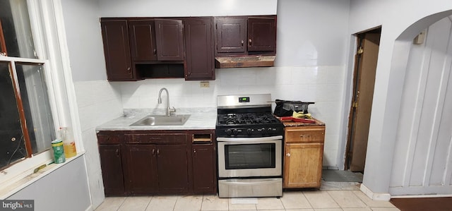 2641 N Bouvier St, Philadelphia, PA 19132 - kitchen featuring exhaust hood, a sink, light tile patterned flooring, light countertops, and gas range