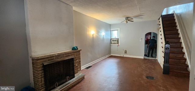2641 N Bouvier St, Philadelphia, PA 19132 - unfurnished living room with stairway, a fireplace with raised hearth, arched walkways, dark wood-type flooring, and a ceiling fan