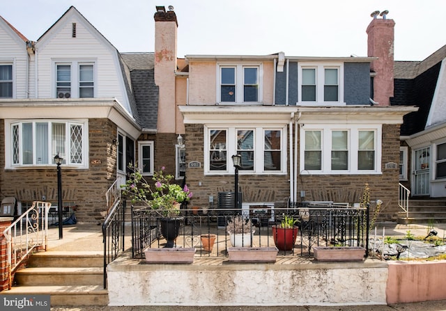 exterior space featuring a chimney, central air condition unit, and a shingled roof