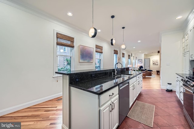 3223 Elliott St, Baltimore, MD 21224 - kitchen with a sink, stainless steel appliances, open floor plan, an island with sink, and ornamental molding