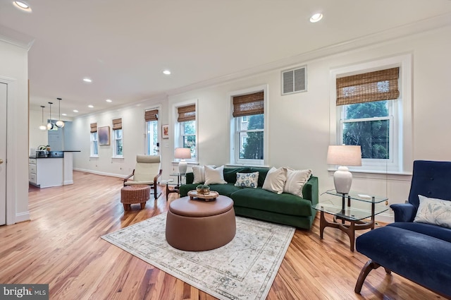 3223 Elliott St, Baltimore, MD 21224 - living room with crown molding, plenty of natural light, light wood finished floors, recessed lighting, and baseboards