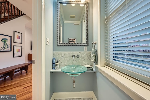 3223 Elliott St, Baltimore, MD 21224 - bathroom featuring a sink, wood finished floors, and ornamental molding