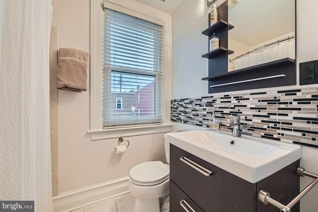3223 Elliott St, Baltimore, MD 21224 - full bath with backsplash, toilet, vanity, tile patterned floors, and baseboards