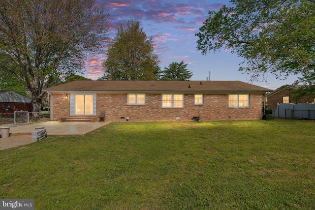 79 Darl Cir, Colonial Beach, VA 22443 - back of house at dusk with brick siding, fence, a patio area, and crawl space