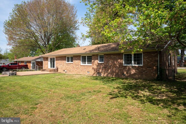 79 Darl Cir, Colonial Beach, VA 22443 - back of house featuring a lawn, fence, a patio area, and brick siding