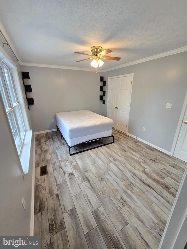 bedroom with baseboards, wood finished floors, and ornamental molding