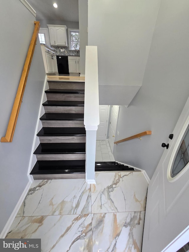 staircase with recessed lighting, marble finish floor, and baseboards