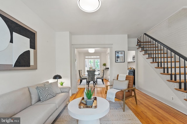 living room featuring light wood-type flooring and stairs