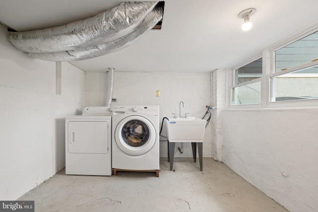 laundry area with washer and dryer, concrete block wall, and laundry area