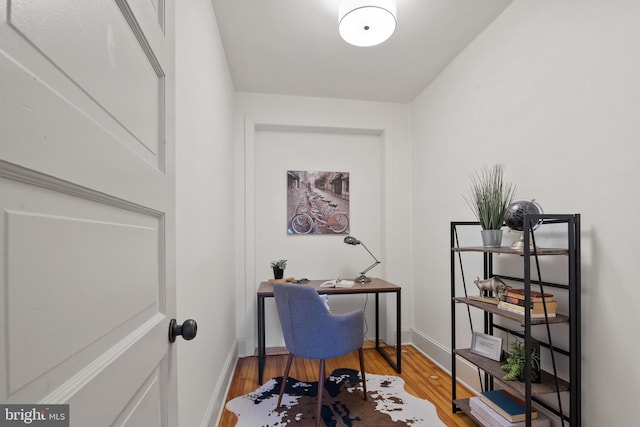 office space with baseboards and wood finished floors