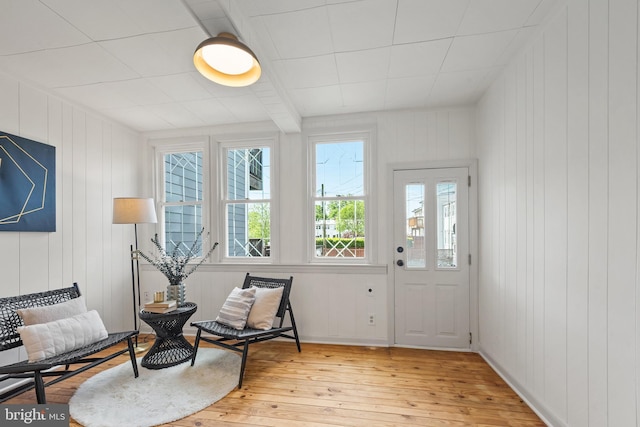 living area featuring wooden walls and light wood finished floors