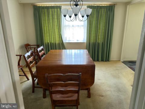 dining room featuring an inviting chandelier and carpet floors