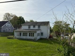 rear view of property with a lawn