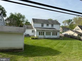 back of property featuring a yard and fence