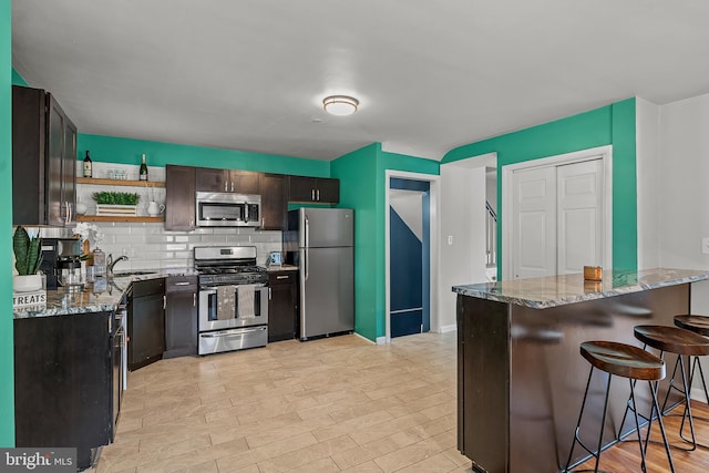 6842 Queens Ferry Rd, Baltimore, MD 21239 - kitchen featuring appliances with stainless steel finishes, light stone countertops, open shelves, and decorative backsplash